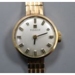 A lady's 9ct gold Tissot manual wind wrist watch, on a 9ct gold strap.