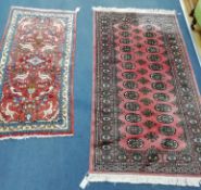 A Bokhara pink ground rug and a small Persian rug, woven with birds and animals (2) Larger 160cm x