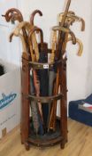 An Edwardian oak stick stand and sundry walking sticks