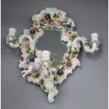 A floral encrusted porcelain three-branch wall mirror