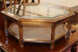 A reproduction octagonal plate glass topped walnut coffee table W.96cm
