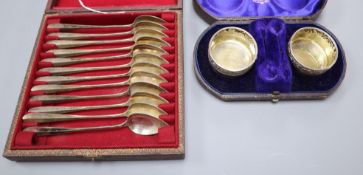 A cased pair of Victorian silver salts and a cased set of twelve white metal spoons.