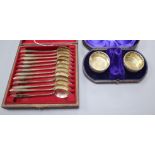 A cased pair of Victorian silver salts and a cased set of twelve white metal spoons.