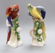 A pair of Sitzendorf Macaws, one red, one blue, each modelled perched on a naturalistic tree stump