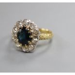 An 18ct, sapphire and diamond set oval cluster ring, size O.