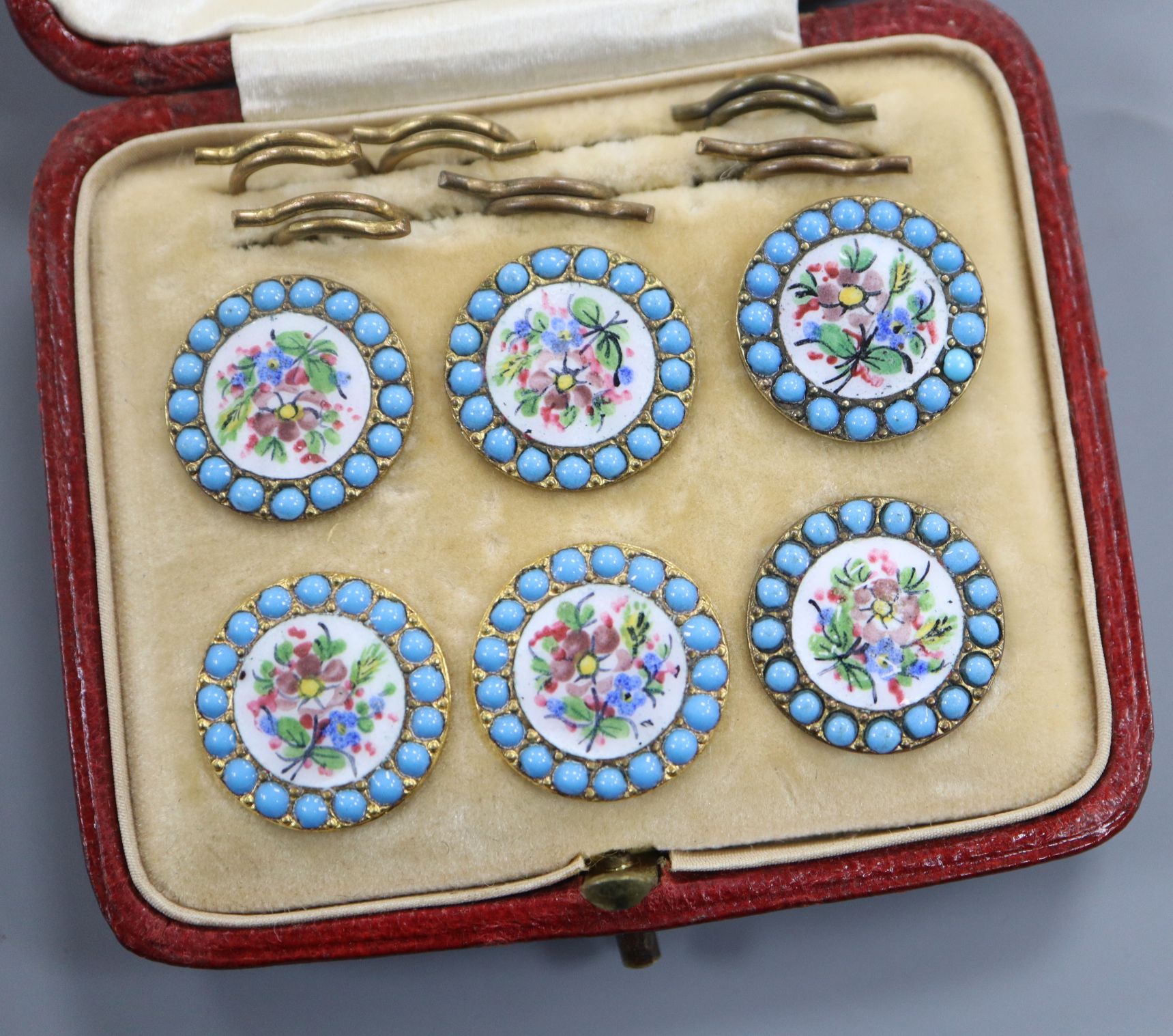 A cased set of six floral and turquoise enamel buttons.
