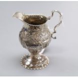 A George III silver cream jug, London, 1779, with later embossed decoration, 11.1cm.