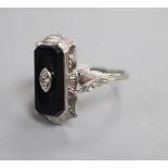 A 10k white metal, black onyx and diamond set shaped rectangular ring, size L.