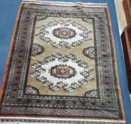 A Bokhara style olive green and cream lozenge patterned rug