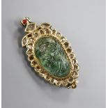 An Indian yellow metal, carved emerald, enamel and rose cut diamond set shaped oval brooch, 41mm.