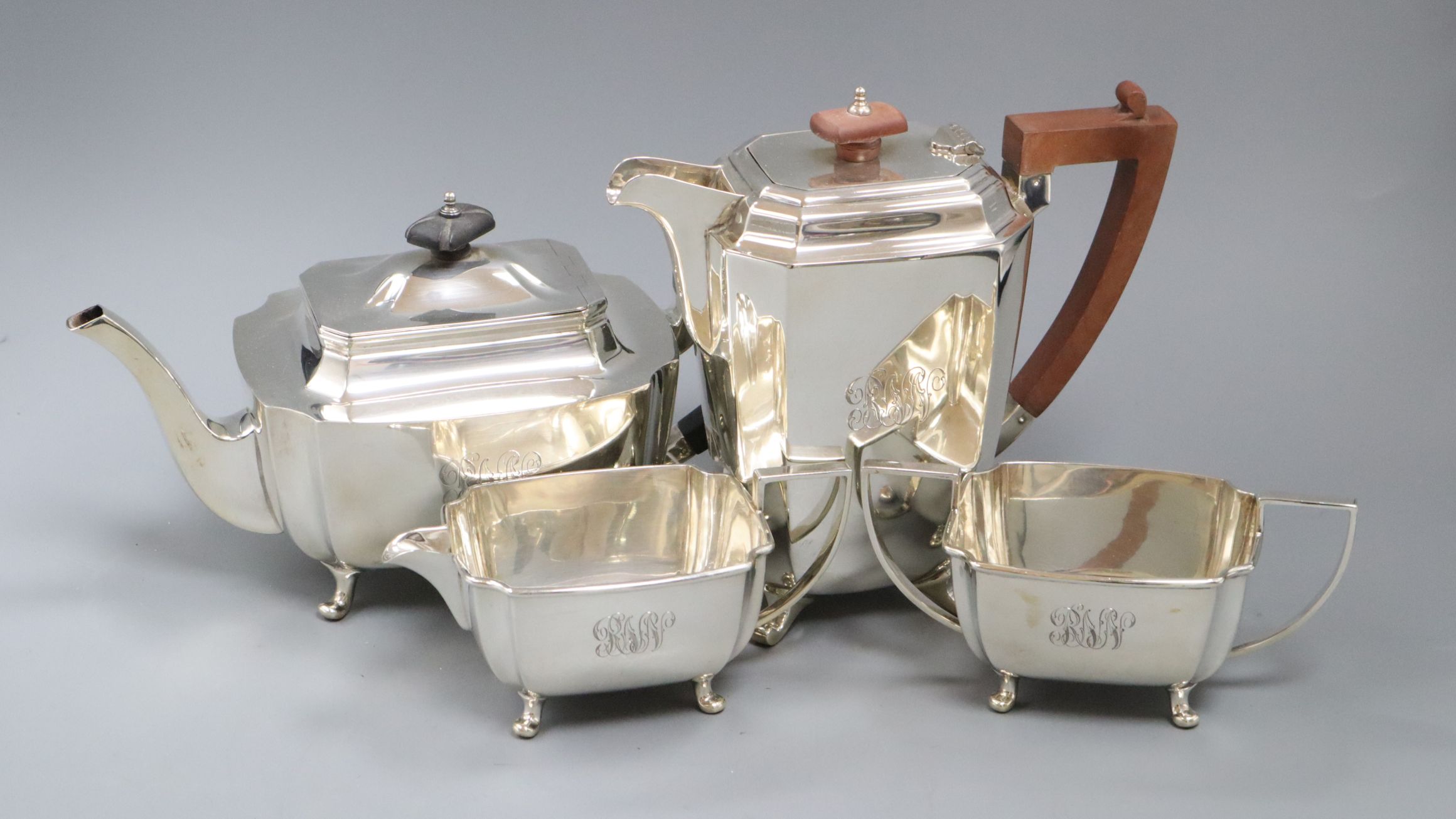 A George VI three piece silver tea set, Sheffield, 1946 and similar silver hot water pot, gross 61.5