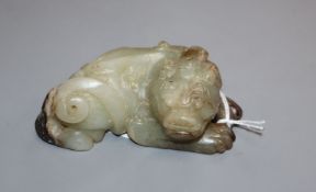 A Chinese pale grey and black jade recumbent lion-dog