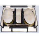 An early 1960's cased engine turned silver mounted four piece brush and comb set.