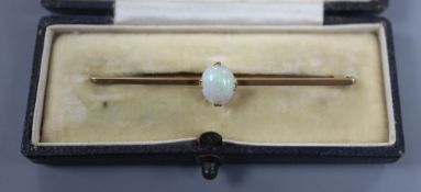 An early 20th century 9ct and white opal set bar brooch, 6cm.