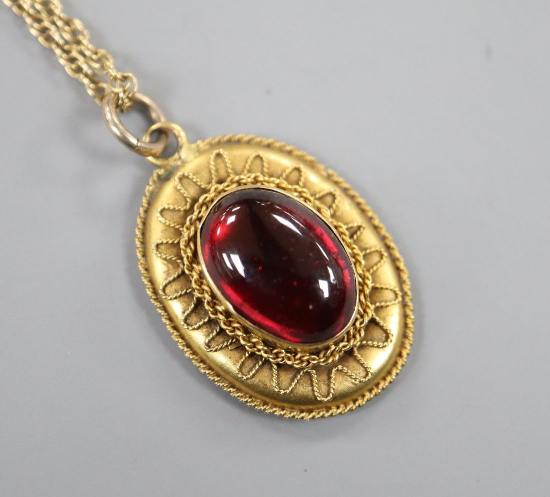 A late Victorian yellow metal and garnet set oval pendant, on a later 9ct gold chain, pendant 24mm.