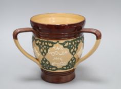 A Doulton Lambeth motto three-handled tyg, c.1895, inscribed 'THE SMALLER THE DRINK....', H. 17.3cm