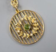 An early 20th century 9ct, peridot and seed pearl set openwork pendant on a gilt metal chain,