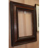 A 19th century Dutch brush grained and ebonised cushion frame wall mirror, lacking plate, W.2ft 7in.