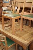 A 1930s oak draw leaf table and four chairs (230cm. extended)