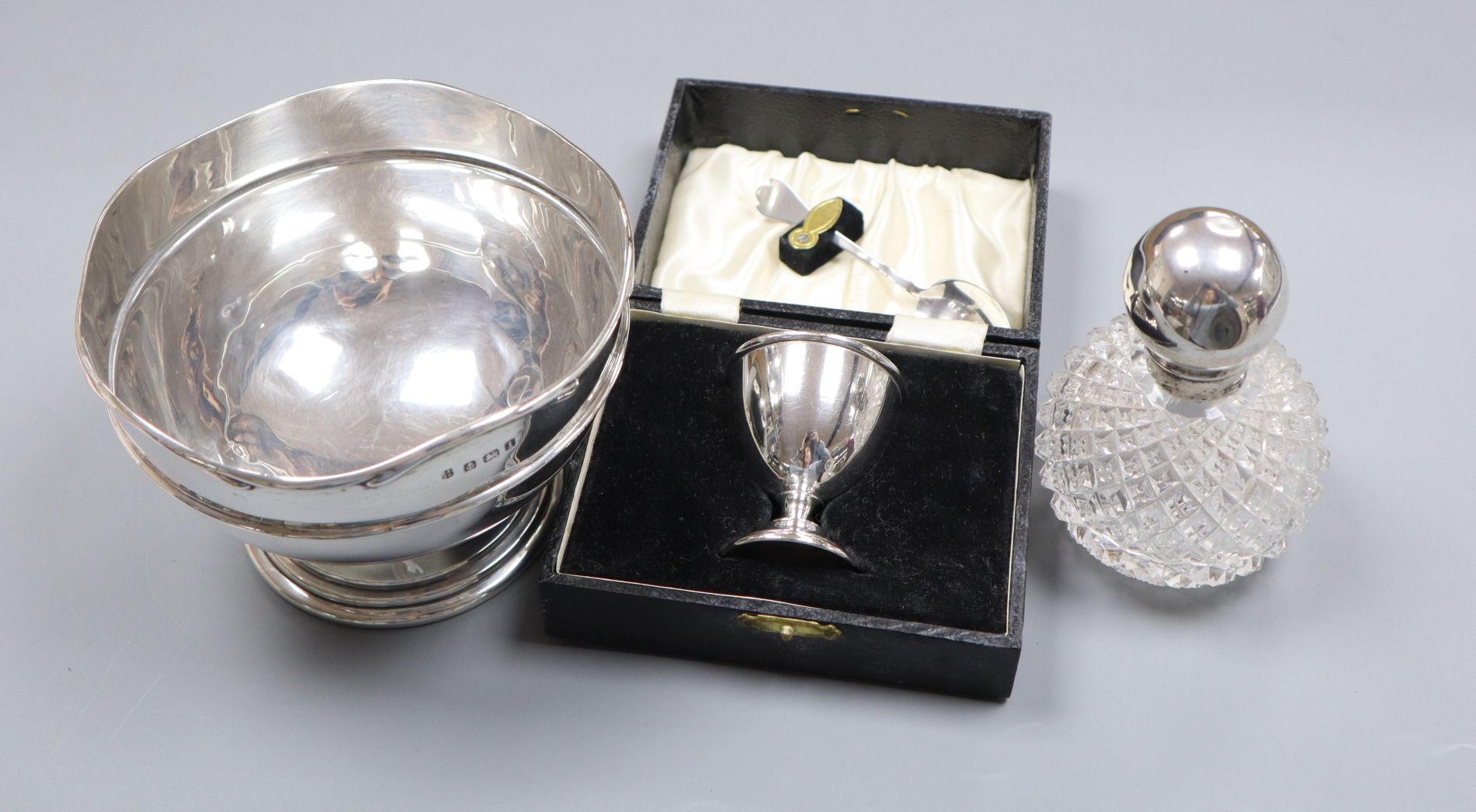 A silver bowl, cased egg cup and silver mounted scent bottle.