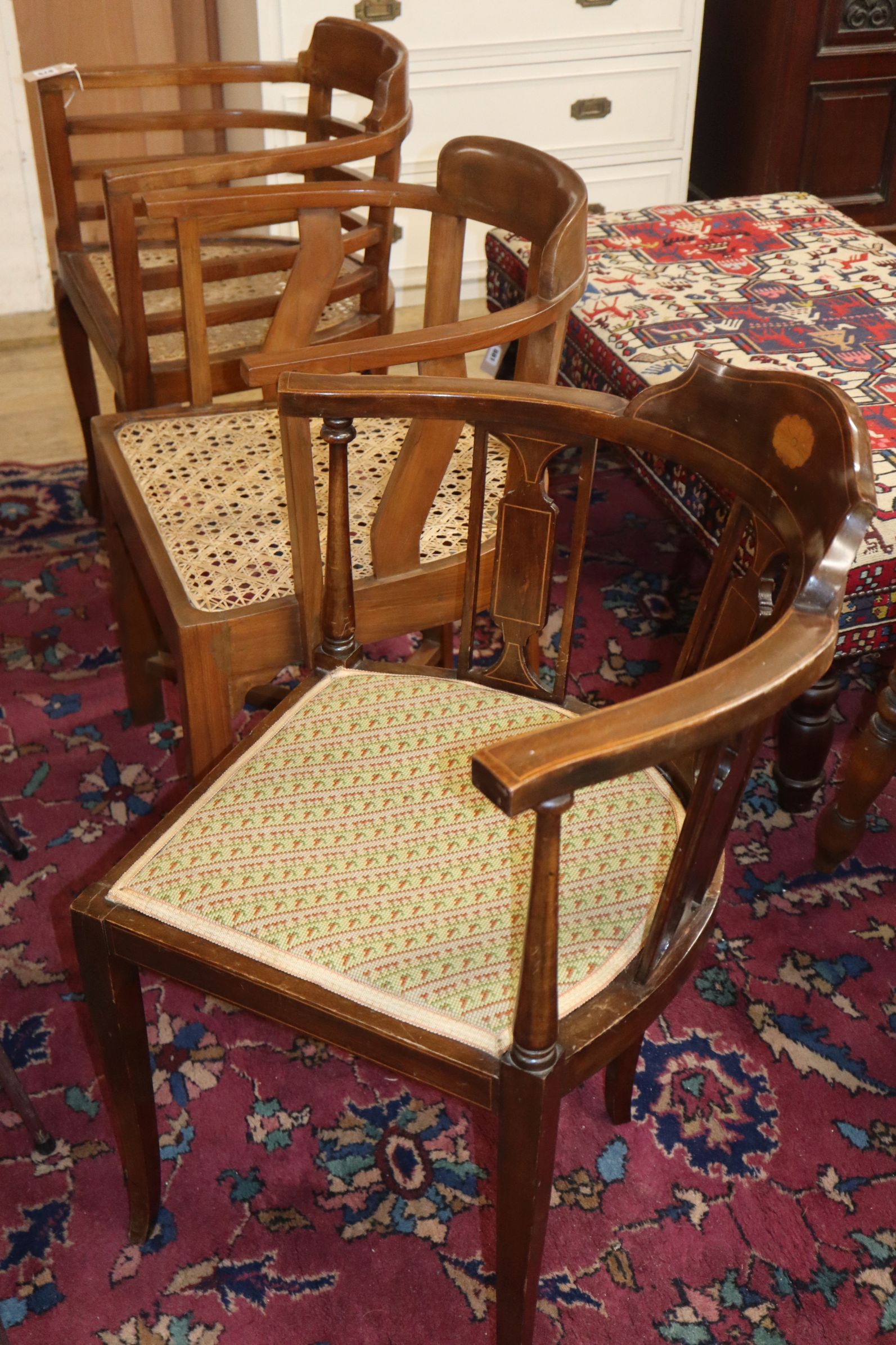 A pair of teak and cane seat tub chairs and a corner chair