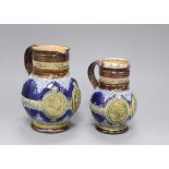 Two Doulton Lambeth graduated Queen Victoria Diamond Jubilee commemorative jugs, c.1896/7, with