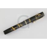 A Dunhill Namiki black lacquered fountain pen, decorated with cranes flying amongst clouds,