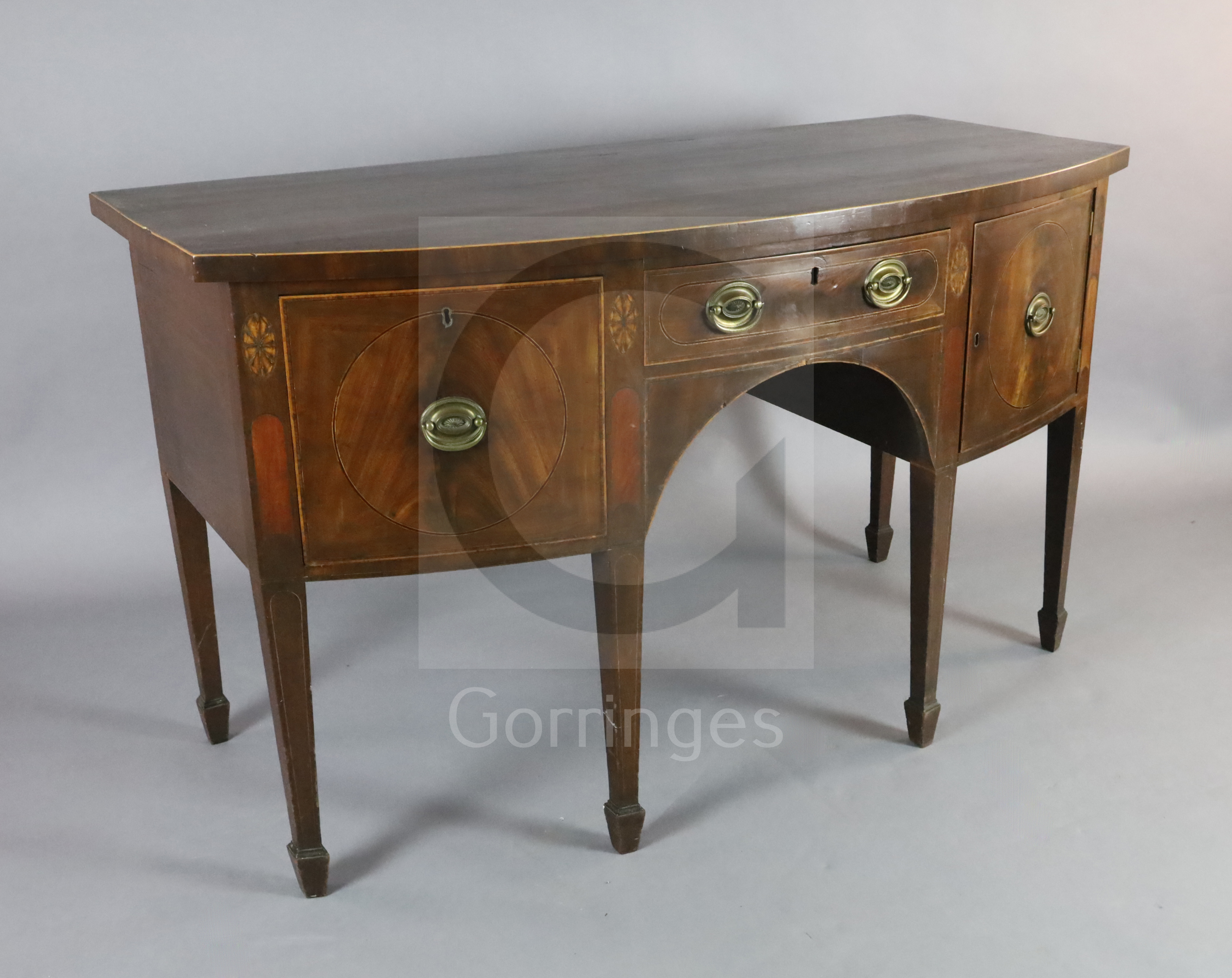 A George III mahogany bowfront sideboard, with central drawer flanked by a cupboard and deep drawer,