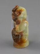 A Chinese pale celadon and russet jade finial, Song dynasty or later, carved in the form a lion with