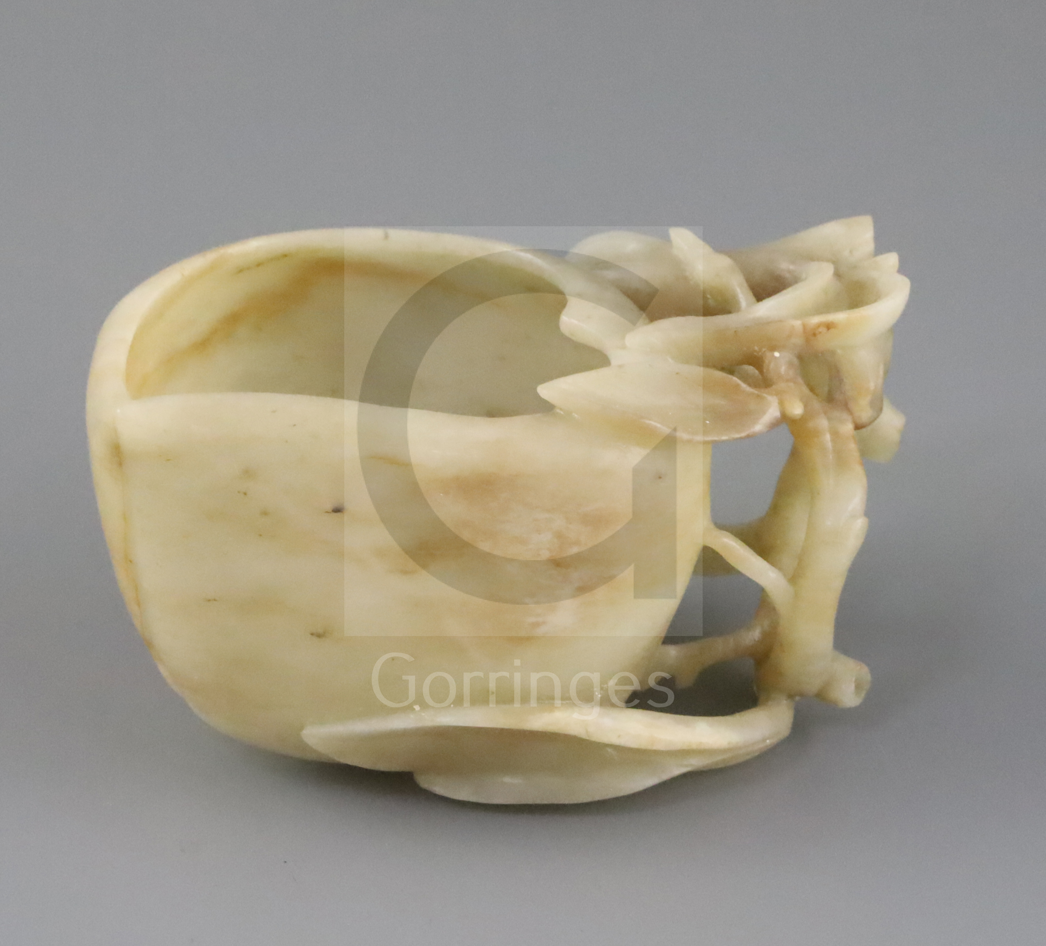 A Chinese jade 'peach' cup, probably 17th / 18th century, the creamy coloured stone with some