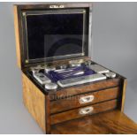 A Victorian burr walnut two drawer travelling toilet box containing ten silver mounted jars or