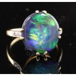 A 1920's 18ct gold, platinum and oval black opal dress ring with diamond set shoulders, size M.