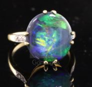 A 1920's 18ct gold, platinum and oval black opal dress ring with diamond set shoulders, size M.