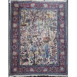 A North West Persian ivory ground rug, with various animals in a field of trees and foliage, with