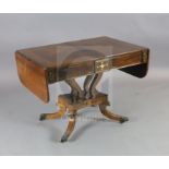 A Regency brass inset rosewood sofa table, with rounded rectangular flaps and two frieze drawers, on