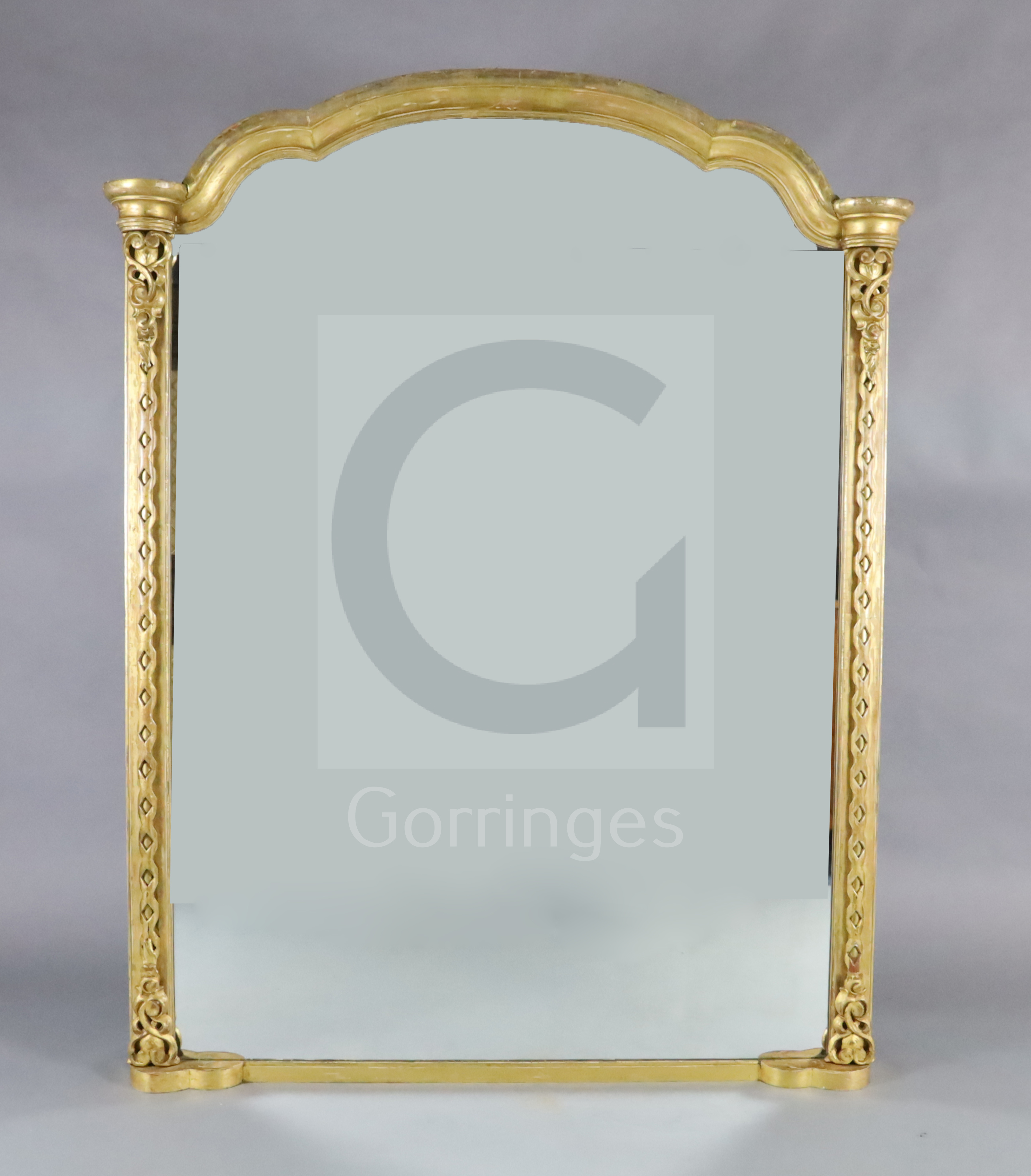 A Victorian giltwood overmantel mirror, with arched top and blind fret carved pilasters, W.4ft