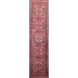 An Ersari red ground runner, with shaped polygons in a field of geometric motifs, 13ft by 3ft 6in.