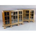 A pair of early 20th century feather banded walnut breakfront dwarf bookcases, with astragal