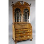 An 17th/18th century walnut bureau bookcase, with broken arch cornice and two astragal glazed