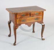 An early 18th century walnut lowboy, with crossbanded quarter veneered top, two short and one long