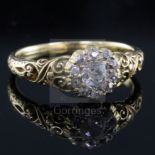 A Victorian gold and eleven stone old cut diamond cluster ring, with carved shoulders and engraved