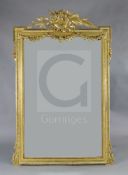 A late 19th French giltwood and gesso wall mirror, with musical pediment and floral swagged