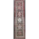 A Persian ivory ground runner, with filed of hooked geometric motifs and multi row border, 13ft