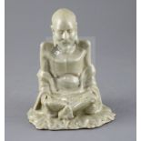 A Chinese celadon glazed figure of Laozi, 18th / 19th century, model cross-legged and seated on