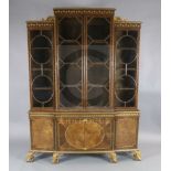 An early 20th century parcel gilt walnut breakfront bookcase, with paterae decorated frieze and four