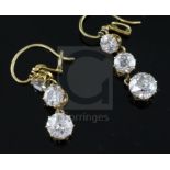 A pair of gold and graduated three stone diamond set drop earrings, the largest stone on each drop