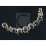 A late Victorian gold and moss agate bracelet, set with nine graduated oval agates, approximately