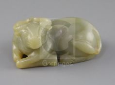 A Chinese celadon and russet jade figure of a recumbent ox, late Qing dynasty, L.8cm