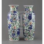 A pair of Chinese wucai vases, Qing dynasty, painted with lotus flowers, scrolling tendrils and