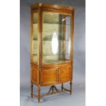 An Edwardian satinwood bowfront display cabinet, with laurel carved frieze, gilt banded central door